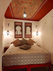 马拉喀什瑞德乐考柏尔酒店的一间卧室配有一张天花板上带两面镜子的床。