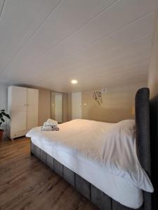 拜特龙Duplex guest house in Batroun的铺有木地板的客房内一张大白色的床