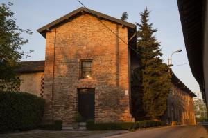 Truccazzano罗坎达圣安娜住宿加早餐旅馆的旧砖砌的建筑,有窗户和门