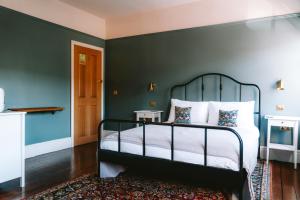 兰戈伦Riversdale House Bed & Breakfast的一间卧室配有一张带绿色墙壁的床