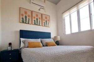 圣米格尔Casa familiar的一间卧室配有蓝色的床和两个黄色枕头