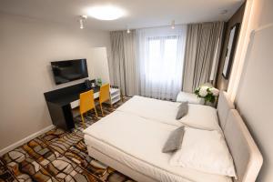 克拉科夫卡齐米日酒店的一间酒店客房,配有一张白色的床和一张书桌