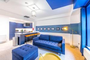 布里斯托Modern Skyfall with FREE PARKING for Families & Business by Prescott Apartments的一间带蓝色沙发的客厅和一间厨房
