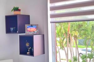 迈阿密Chic Ocean Miami 88的一间设有窗户的客房,配有紫色橱柜