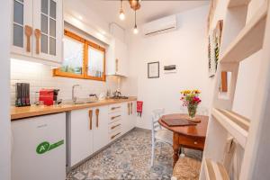阿莫利亚尼岛Ammou Area的厨房配有白色橱柜和木桌