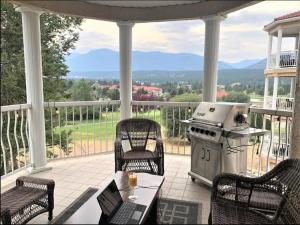 费尔蒙特温泉Mountain View Vacation Villa Main Floor Unit, No Stairs的门廊设有烧烤架、桌子和椅子