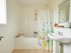 Les Forges莱斯福吉斯2号别墅的浴室配有水槽、浴缸和淋浴帘