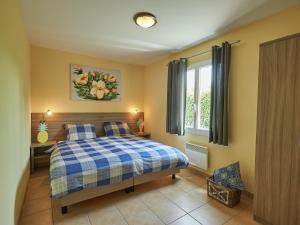Les Forges莱斯福吉斯2号别墅的一间卧室配有一张带蓝白色布艺毯的床