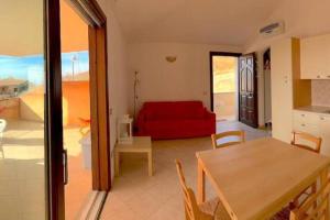 特里尼达古图Casa Smeralda - Piscina e vista sul Mare!的客厅配有红色的沙发和桌子