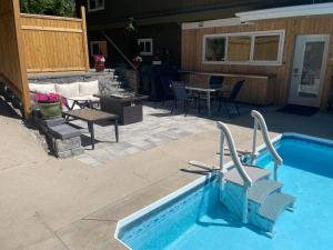 彭蒂克顿Bright poolside walkout two bedroom basement suite in the Okanagan的一个带桌椅的游泳池和一个庭院