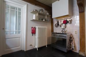 蒙尼肯丹Waterland Achterhuis的厨房配有炉灶、暖气和门
