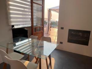 巴科利DOMUS PARVA - Villa con bio-piscina, spa privata e appartamenti panoramici的壁炉间里的玻璃桌和椅子