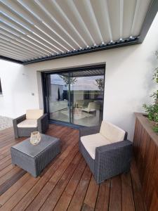 BrieLa Suite的木质甲板上配有柳条家具的庭院