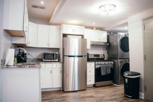 巴尔的摩Fells Point Charm Doubled!的厨房配有白色橱柜和不锈钢冰箱