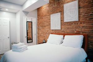 巴尔的摩Fells Point Charm Doubled!的一间卧室设有砖墙和一张床