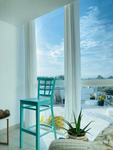 查梅Tu Apartamento en Coronado的一张蓝色椅子,坐在大窗户前