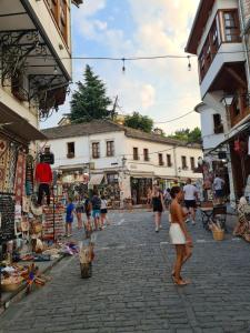 吉诺卡斯特SANTA ROOM-OLD BAZAAR CENTER-Gjirokaster的一群人走在一条商店林立的街道上