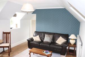 布莱尔高里The Loft at Craigmill House的客厅配有黑色真皮沙发和绿色墙壁