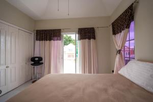 尼格瑞尔JAG Guesthouse- Little Bay Country Club的一间卧室设有一张大床和一个窗户。