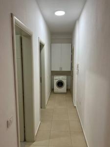 地拉那Apartment Astiri的走廊上设有洗衣机