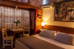 弗洛里亚诺波利斯Pousada Mar de Dentro的一间卧室配有一张床、一张桌子和一个窗户。