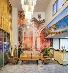 安塔利亚Grand Gulluk Hotel & Spa的大堂配有沙发、椅子和壁画