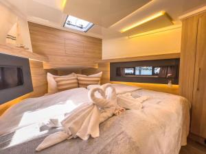 费曼城堡Motoryacht-Futura-Urlaub-im-Yachthafen的一间卧室配有一张大床,上面有天鹅