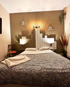 奥弗涅库尔农Hotel Le Midi Clermont-Cournon的一间卧室配有一张大床,两盏灯
