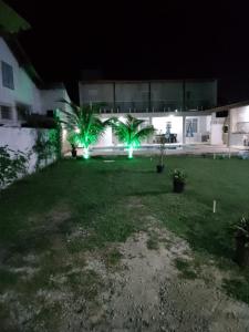 大伊瓜巴Casa Temporada Privativa RJ的两棵棕榈树和绿灯的院子