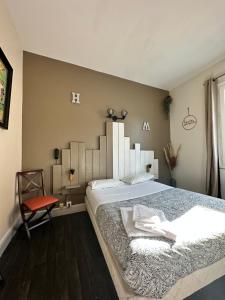 奥弗涅库尔农Hotel Le Midi Clermont-Cournon的一间卧室配有一张大床和一张红色椅子