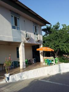 Karadut内姆鲁特艾斯克潘什汽车旅馆的一座带橙色遮阳伞和桌椅的房子