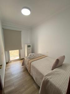 加尔达尔Ático Playa Sardina的一间卧室设有两张床和窗户。