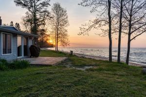 StephensonWaterfront Lake Michigan Hideaway Private Beach!的日落时分在海边的房子