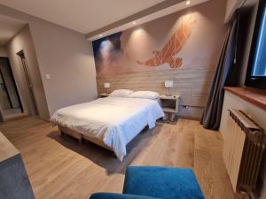 圣卡洛斯-德巴里洛切Hotel Alun Nehuen的卧室配有一张床,墙上挂有绘画作品