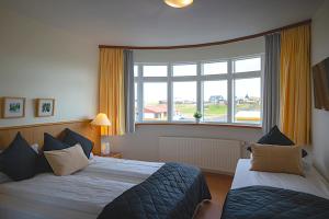 海德利桑德Adventure Hotel Hellissandur的酒店客房设有两张床和大窗户。