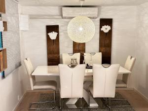 斯塔万格«Sea View Apartment Finnøy Island»的餐桌、白色椅子和吊灯