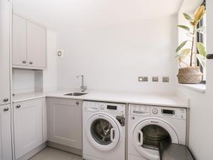 切尔滕纳姆Suncroft的白色洗衣房配有洗衣机和烘干机