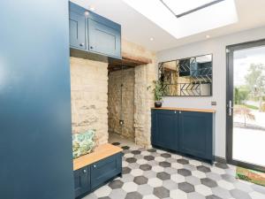 切尔滕纳姆Suncroft的厨房配有蓝色橱柜和 ⁇ 格地板