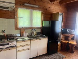 志摩市Log house Hata - Vacation STAY 29001v的厨房配有黑色冰箱和水槽