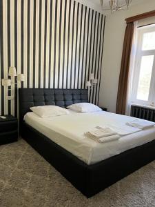 西格纳吉皮洛斯曼尼60号旅馆的一间卧室配有一张大床和黑色床头板