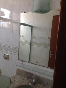 瓦尔任阿Aconchego bem localizado的一间带镜子和水槽的浴室