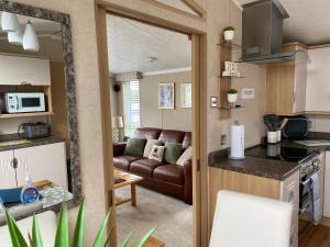 SwarlandCosy & Modern Cabin In Heart of Northumberland的厨房以及带沙发的起居室。