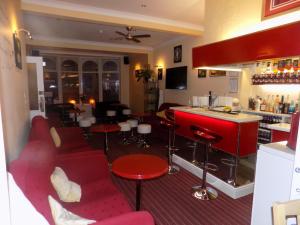 布莱克浦诺伍德住宿加早餐旅馆的一间酒吧,配有红色的椅子和红色的柜台