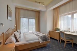 菲根考斯腾泽公寓的一间卧室配有一张床、一张书桌和一个窗户。