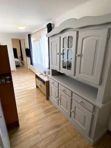 海尔许霍瓦德La Luna - Danny的厨房铺有木地板,配有白色橱柜。
