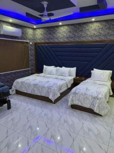 卡拉奇Defence Orchard DHA Karachi的蓝色灯的客房内的两张床