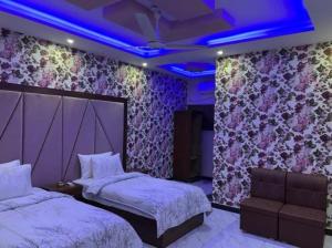 卡拉奇Defence Orchard DHA Karachi的一间卧室设有两张床和一个紫色的天花板