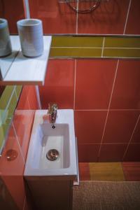 莱斯诺夫Cabana Bendis的浴室设有白色水槽和红色瓷砖