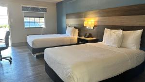 维斯塔Days Inn by Wyndham San Diego Vista的酒店客房配有两张床和一张书桌