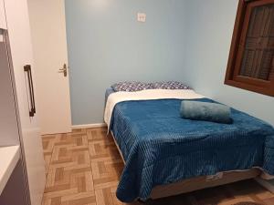 卡内拉Casa na Serra Gaucha Canela的一间卧室配有一张带蓝色毯子的床
